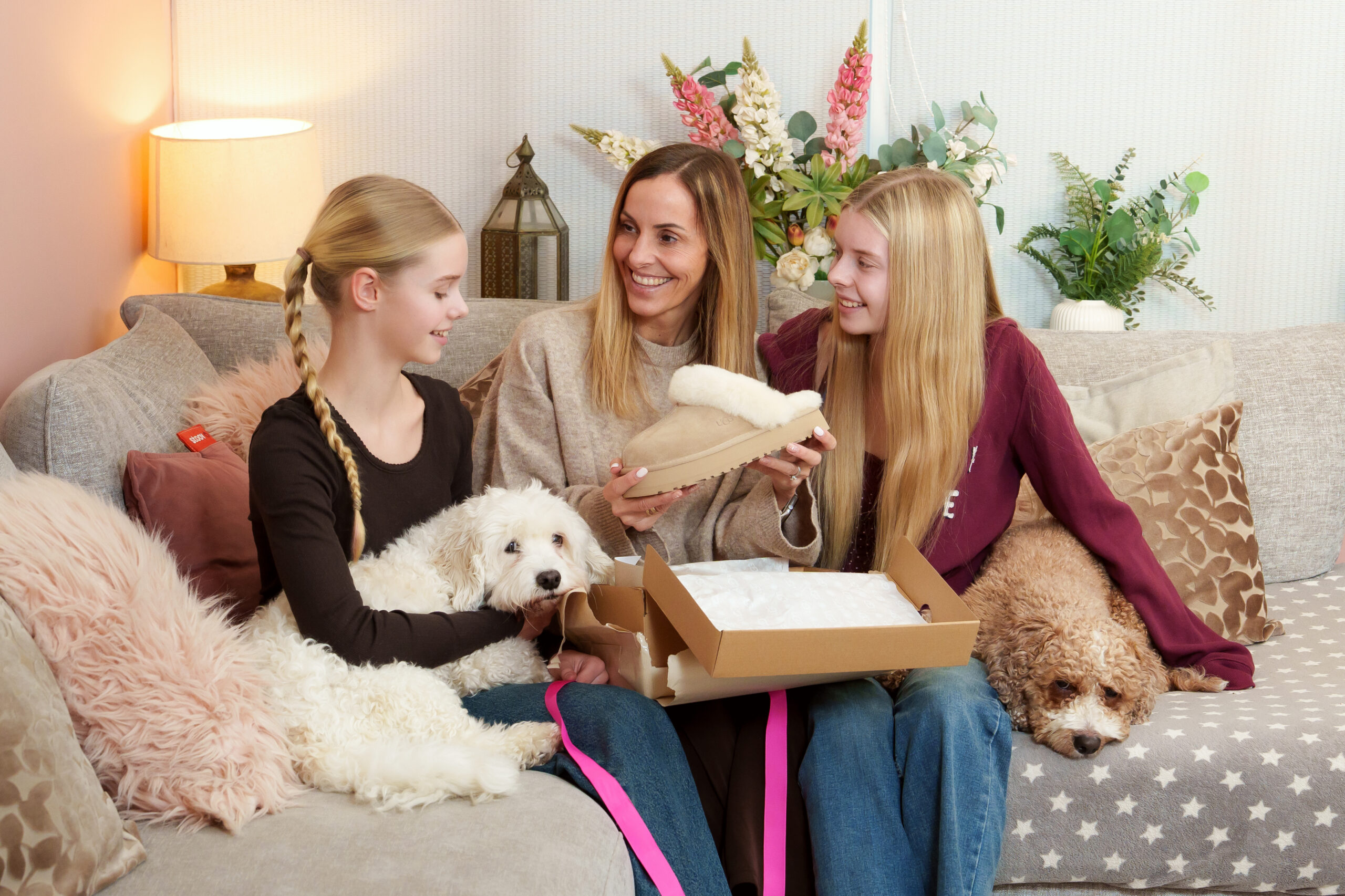 Mother opening cosy slipper gift with her daughters at home