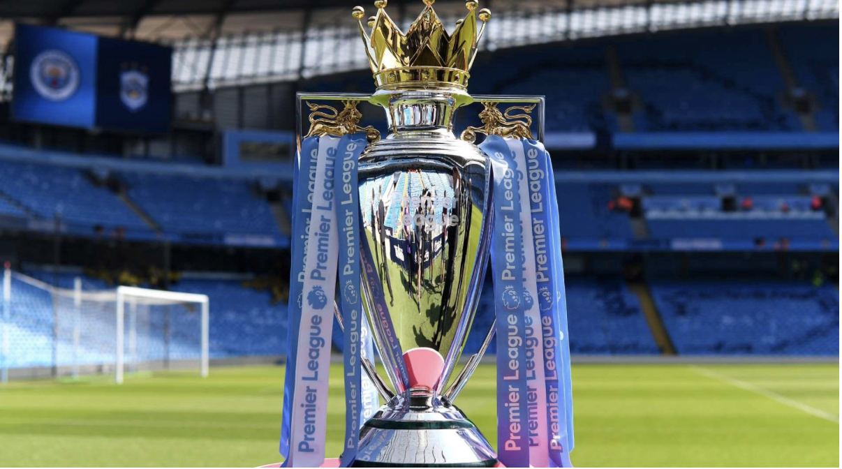 Premier League trophy displayed on the pitch inside a football stadium